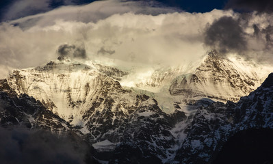 The dramatic snow covered peaks of the Dhaulagiri range covered with stormy clouds as seen from the Himalayan village of Tukuche on the Annapurna Circuit trek in Nepal.