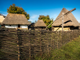 Wooden houses with roof of straws and fence of wood. Old houses architecture countryside Transylvania.