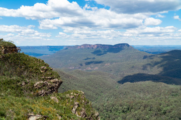 Naklejka premium Panoramic Blue Mountains Australia. Dramatic views of peaks, rock, valley, landscape, green rainforest jungle. Adventure, freedom, fun concepts. Tourist mountain trek. Shot in Sydney, NSW.