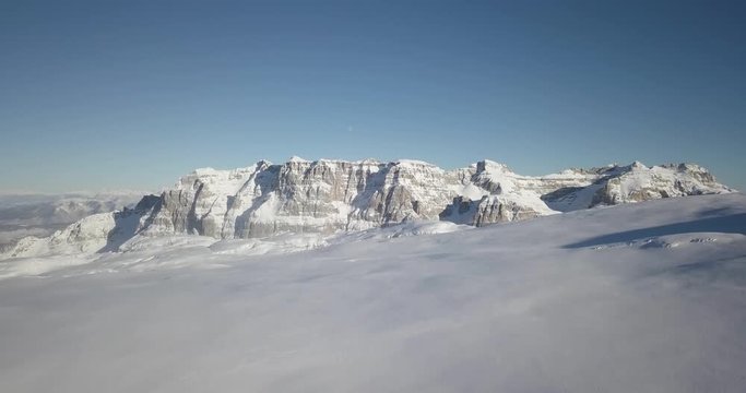 Aerial Reveal shot with view of mountain landscape on Dolomite Alps with snow in Madonna di Campiglio, Val Rendena, Italian Alps, Italy