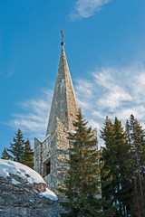 Stone church steeple with cross in winter