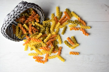 
Colored pasta scattered on wooden table