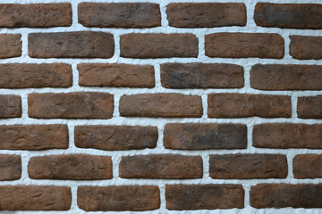 Brown stone wall with white seams, decorative facing brick texture, background