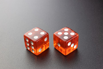 Two red glass dice on a black matte background with side lighting. Four and five with copy space.