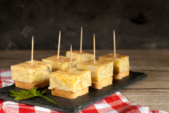 Spanish omelette brochettes on wooden table