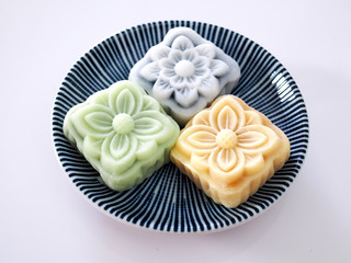 Top view of colorful snow lotus dessert, mooncake bua hema on dish isolated on white background.