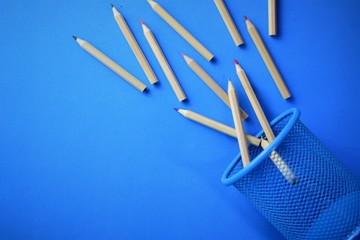 Fallen colored pencils on blue background