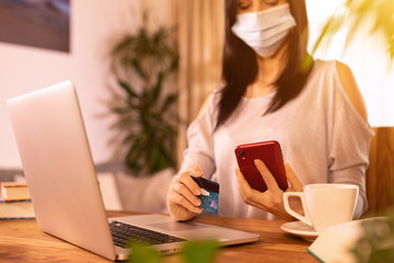 Woman is holding credit card and using laptop computer. Online shopping concept.