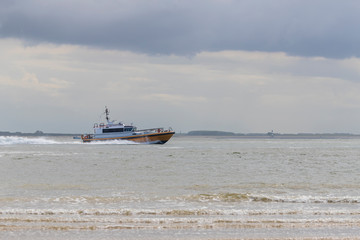 A fast cruiser sails out to sea.