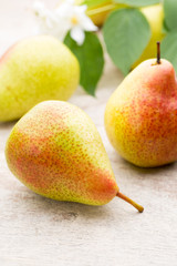 Fresh pears with leaves in a on wooden background.