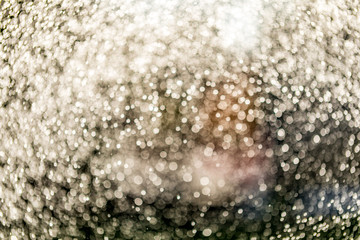 Abstract splashes of water on bokeh background in sunshine. Freeze motion of white particles. Rain, snow overlay texture.