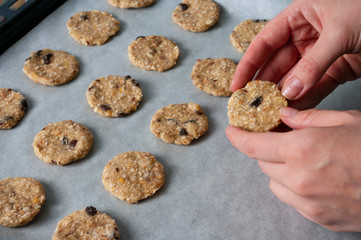 fresh oat cookies, hold in hand, process baking. vegetarian food, sweets. Home made.