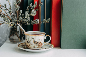 a Cup of tea, books and willow branches on the windowsill