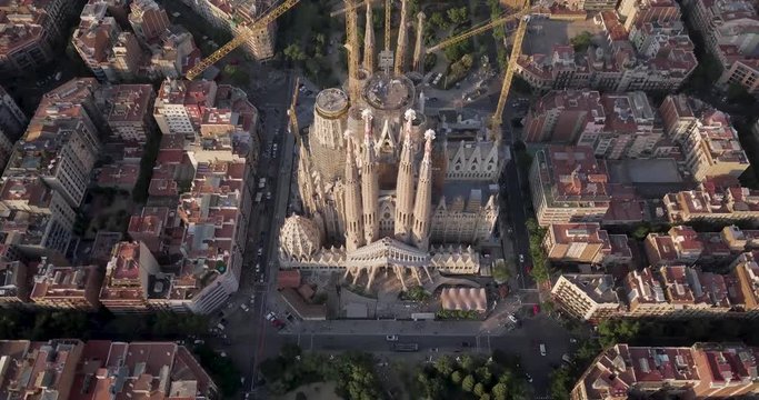 La Sagrada familia cathedral, Aerial, tracking, drone shot,panning vertical the La Sagrada familia cathedral, over the city of Barcelona, at sunset.