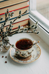 a Cup of tea, books and willow branches on the windowsill