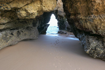High rocks in the blue sea. Yellow sand on the beach.