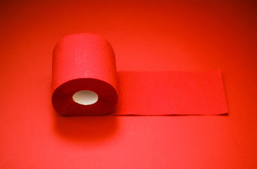 The roll of toilet paper isolated on lush lava red background. A supply of toilet paper in case of a pandemic. COVID-19 coronavirus outbreak concept. Shortage due to buying panic. Сopy space.