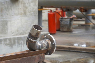 Pipeline DN 100. Branch + pipe. A section of the pipeline for an oil refinery amid technological equipment.