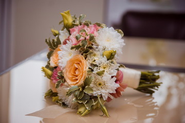 Bridal bouquet of roses, eustoma and decorative plants on wooden background
