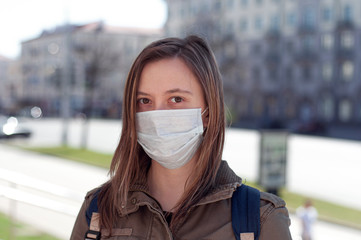 Woman in mask on street because of air pollution and epidemic in city
