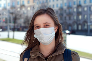Woman in mask on street because of air pollution and epidemic in city