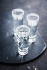 Tequila shots on the dark rustic background. Selective focus. Shallow depth of field.