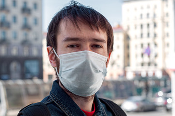 man in mask on street because of air pollution and epidemic in city