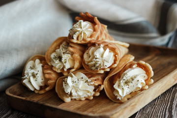 Russian waffles with cream cheese and spices. Wafer rolls on the table. Delicious waffles