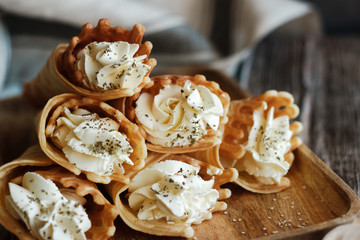 Russian waffles with cream cheese and spices. Wafer rolls on the table. Delicious waffles
