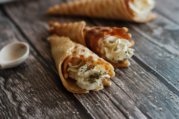 Russian waffles with cream cheese and spices. Wafer rolls on the table. Delicious waffles
