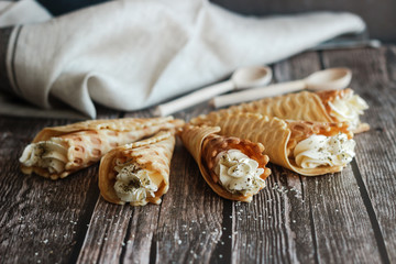 Russian waffles with cream cheese and spices. Wafer rolls on the table. Delicious waffles