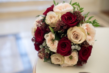 Bridal bouquet of red and cream roses, eustoma and ornamental plants
