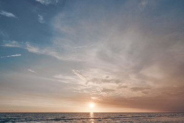 Naklejka na ściany i meble Stunning colorful sunset on a sandy beach.