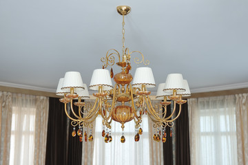 A large classic gold-colored chandelier against a white ceiling.