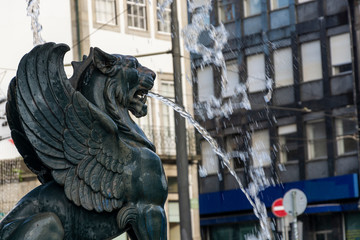 Fototapeta na wymiar Fonte dos Leões (Lions' fountain). Lion statue with wings expelling water from the mouth.