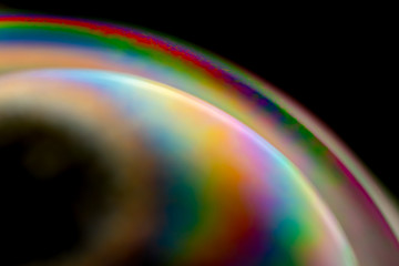 Psychedelic abstract planet from soap bubble, Light refraction on a soap bubble, Macro Close Up in soap bubble. Rainbow colors on a black background. Model of Space or planets universe cosmic galaxy.