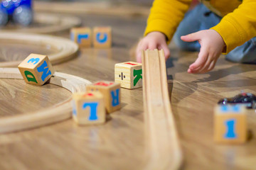 Obraz premium Child playing with blocks and a wooden train track