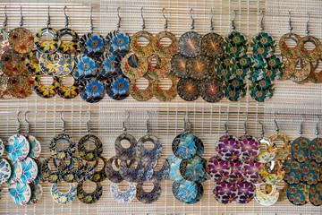 Colorful handmade earrings for sale for tourists at the street market in Hoi An old town, Vietnam