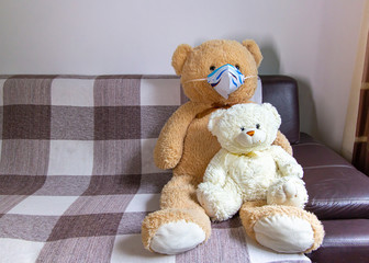 Generic bear toy in couch wearing handmade paper mask - lockdown covid-19