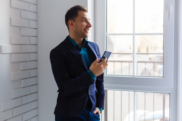 Fototapeta premium portrait of a young man standing by packages in empty office