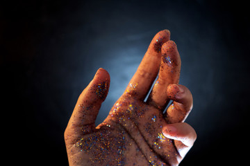 Female hand covered with sequins. The movement of palm of your hand and Shine multicolored glitter,