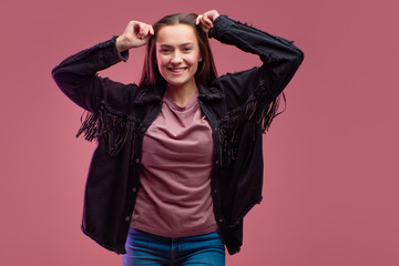 Young brunette woman on pink background. Studio portrait, informal style of clothing,