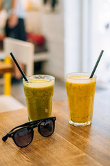 Two glasses of appetizing smoothie in summer cafe. Vegetable smoothie