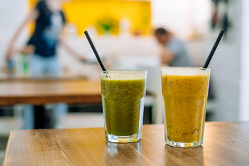 Two glasses of tasty smoothie on wooden table. Vegetable and fruit smoothies