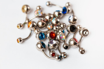 Colored navel piercings on white background