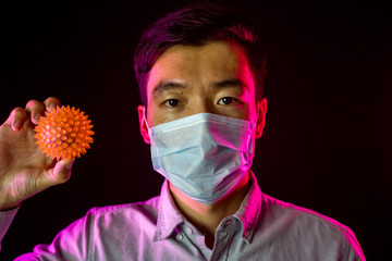 Portrait of asian man. Chinese guy in protective mask against covid-19 with spiked ball. Black...