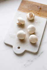 Fresh sliced champignon mushrooms on cutting board.