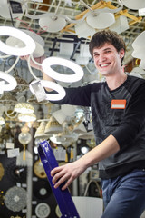 Happy young man browsing for lights fixture in store