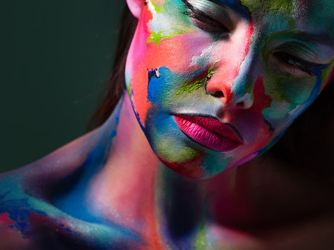 Face art and body art. Creative makeup with colorful patterns on the face. Modern makeup art, bold style,