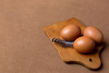 egg feather on a wooden cutting Board on a brown background